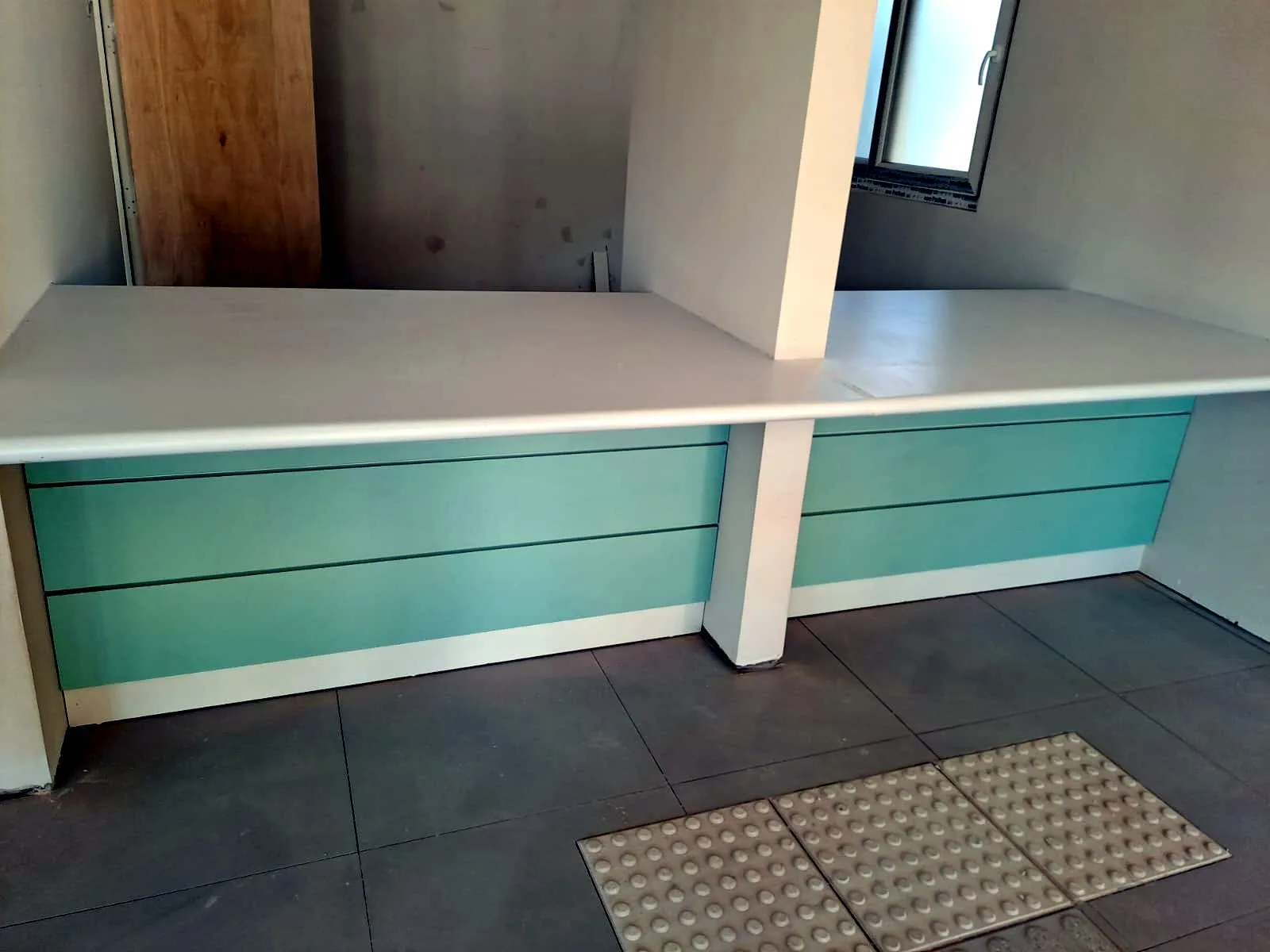 Cubierta postformada blanca instalada sobre un mueble de atención
