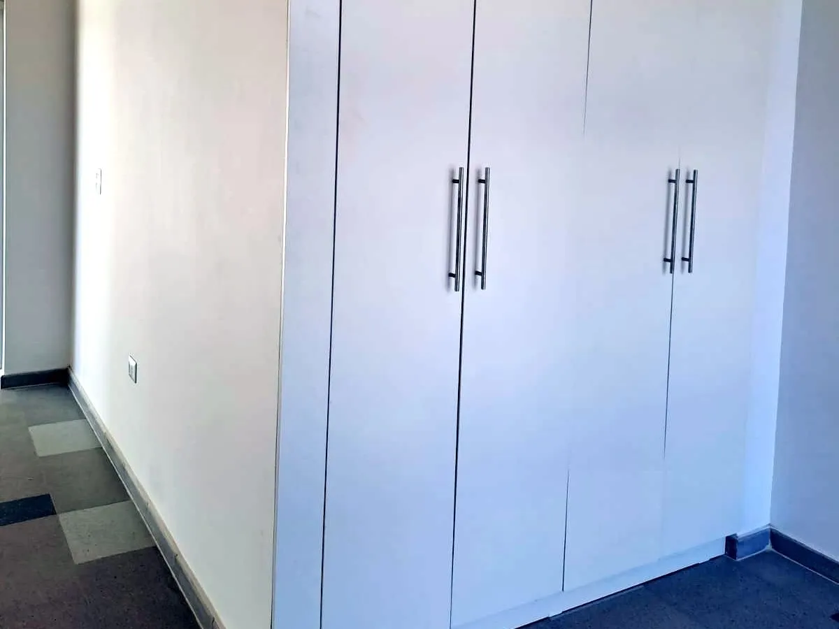 Roperos empotrados a medida, terminación blanca, en un proyecto ejecutado por el taller
